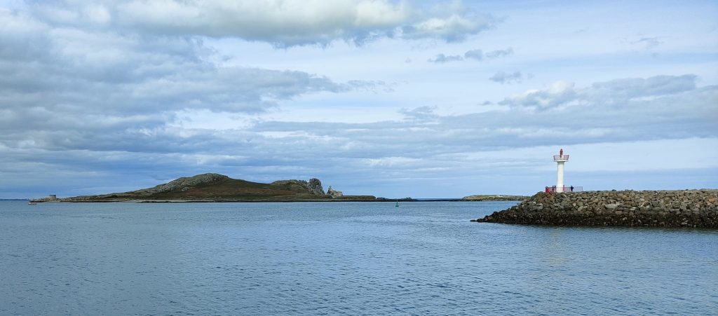 An island, Ireland's Eye, is in the centre of the photo, with a light at the end of Howth harbour on the right.
