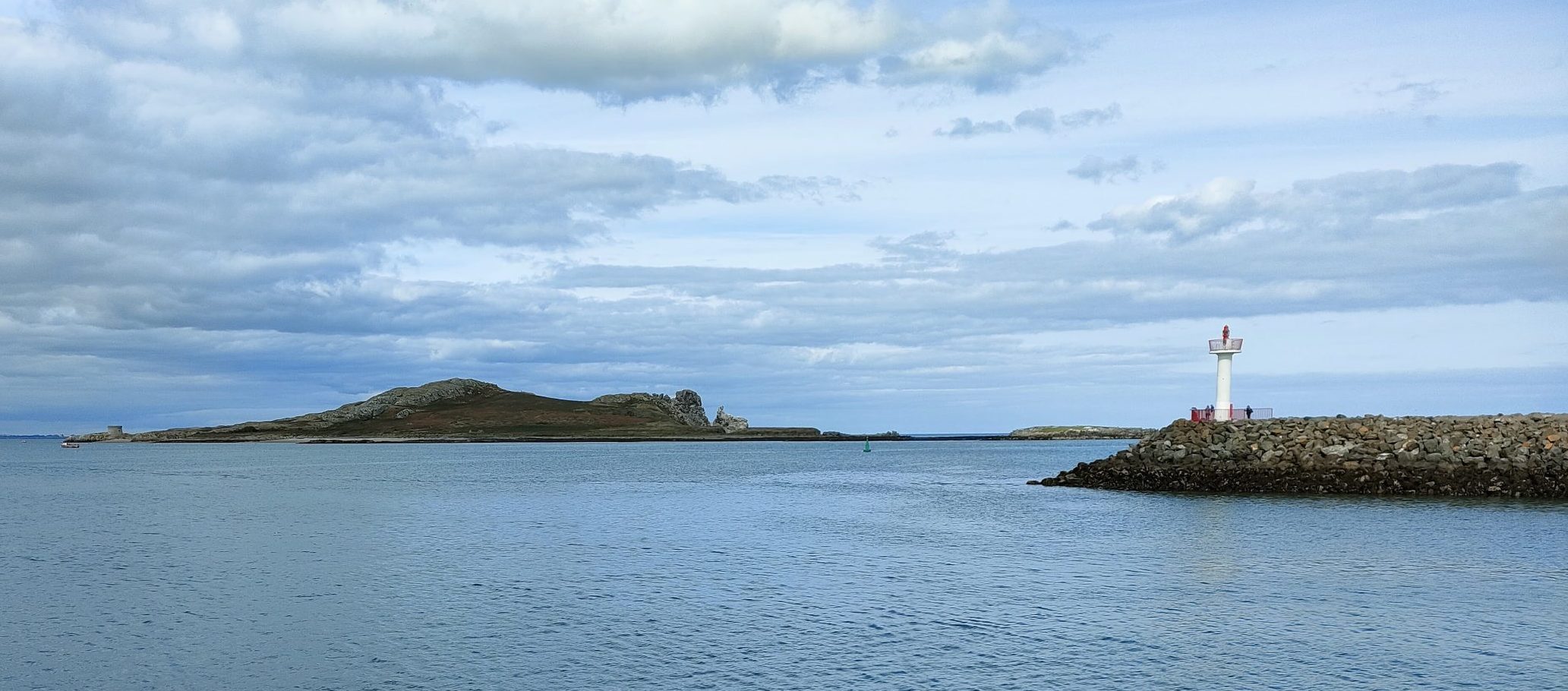 An island, Ireland's Eye, is in the centre of the photo, with a light at the end of Howth harbour on the right.